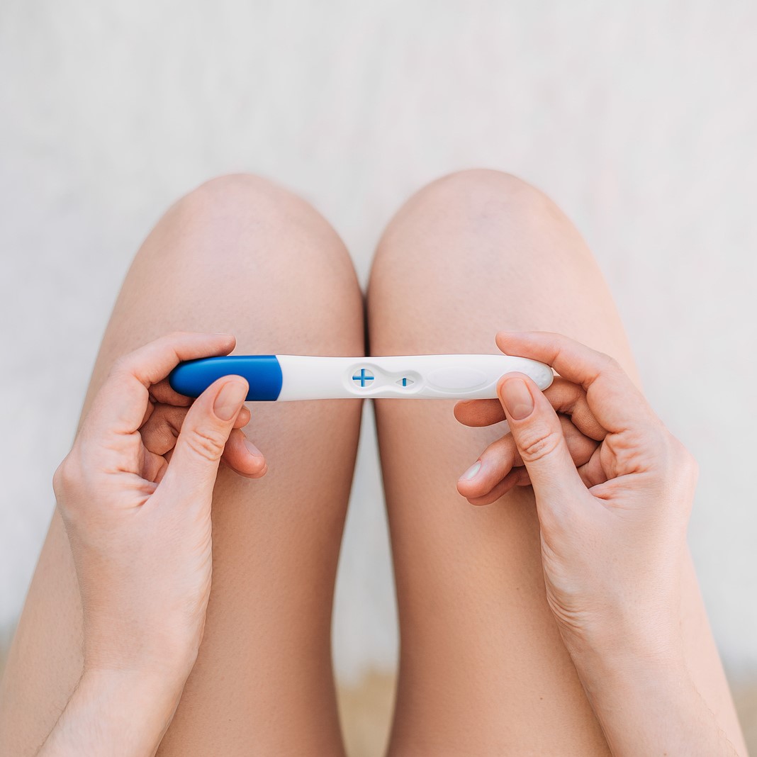 A woman holding a free pregnancy test in Arlington, Texas